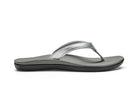 A silver Olukai Junior Girls Ho'opio flip-flop sandal with a grey sole on a white background