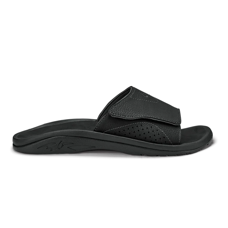 Black Olukai Men's Nalu Slide sandal with a strap on a white background