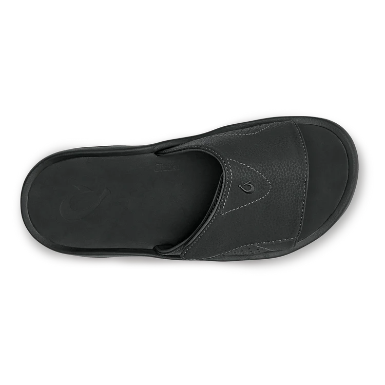 Black Olukai Men's Nalu Slide sandal with a strap on a white background