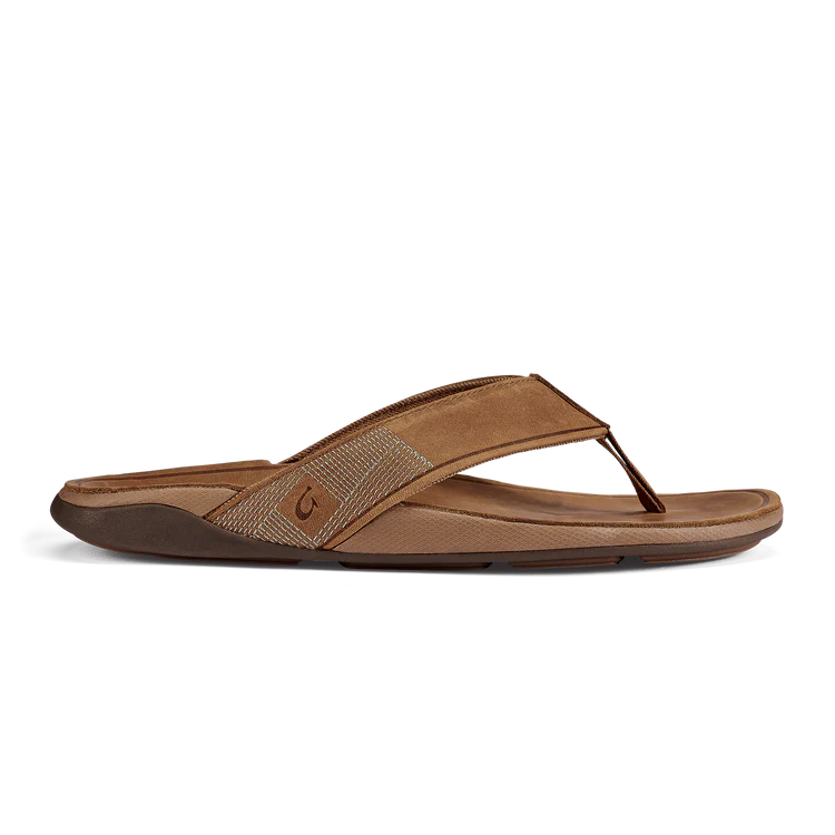A brown leather Olukai Men's Tuahine flip-flop sandal on a white background