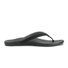 A black Olukai Women's Ho'opio flip-flop sandal on a white background