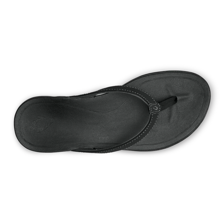 A black Olukai Women's Ho'opio flip-flop sandal on a white background