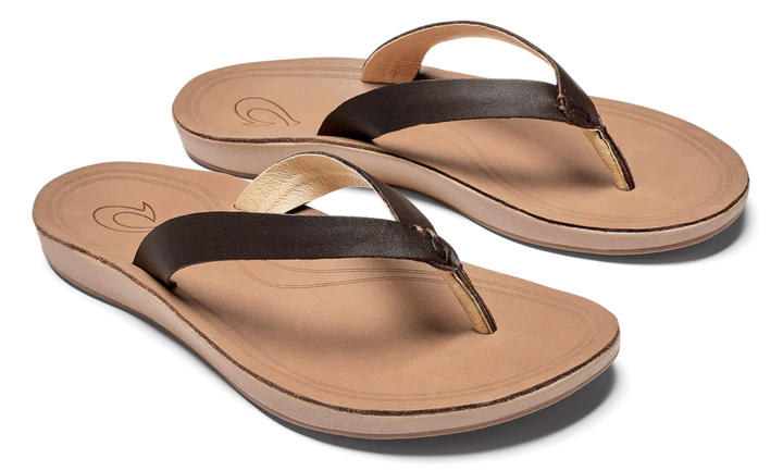 A pair of brown leather Olukai Women's Nonohe flip-flop sandals on a white background