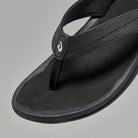 A black Olukai Women's Ohana flip-flop sandal on a white background