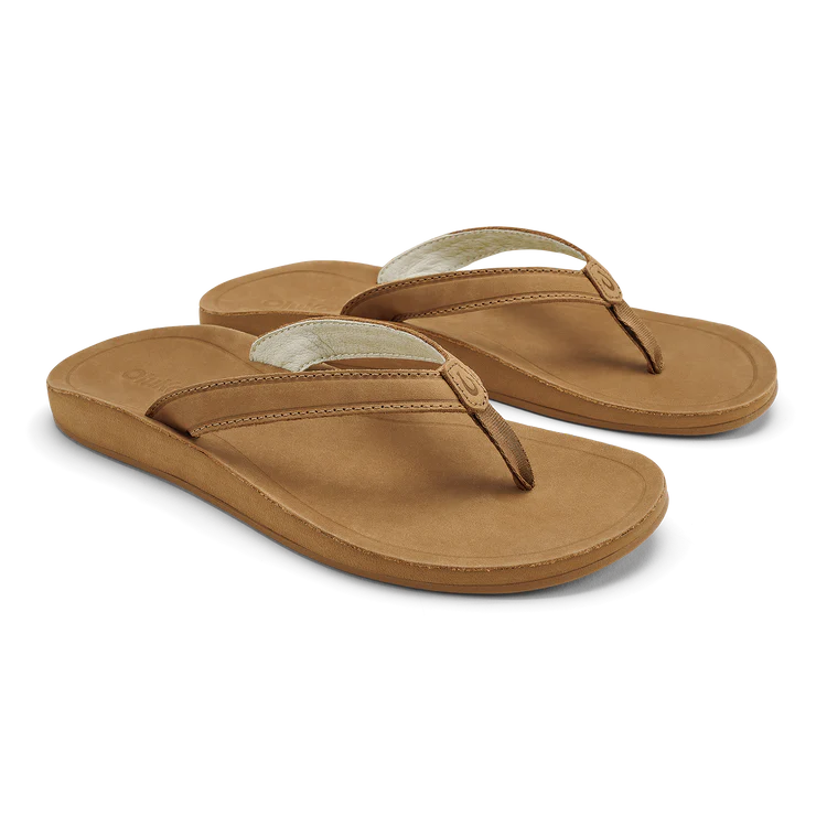 A pair of brown leather Olukai Womens Southshore flip-flop sandals on a white background