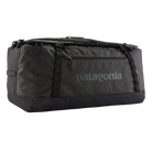 Front view of the black on black Patagonia Black Hole Duffel 100L featuring weather-resistant TPU-laminated ripstop fabric, removable ergonomic backpack shoulder straps, reinforced end haul handles, a padded base, and heavy-duty exterior daisy chain lash loops.