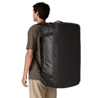 Rear view of the black on black Patagonia Black Hole Duffel 100L featuring weather-resistant TPU-laminated ripstop fabric, removable ergonomic backpack shoulder straps, reinforced end haul handles, a padded base, and heavy-duty exterior daisy chain lash loops.