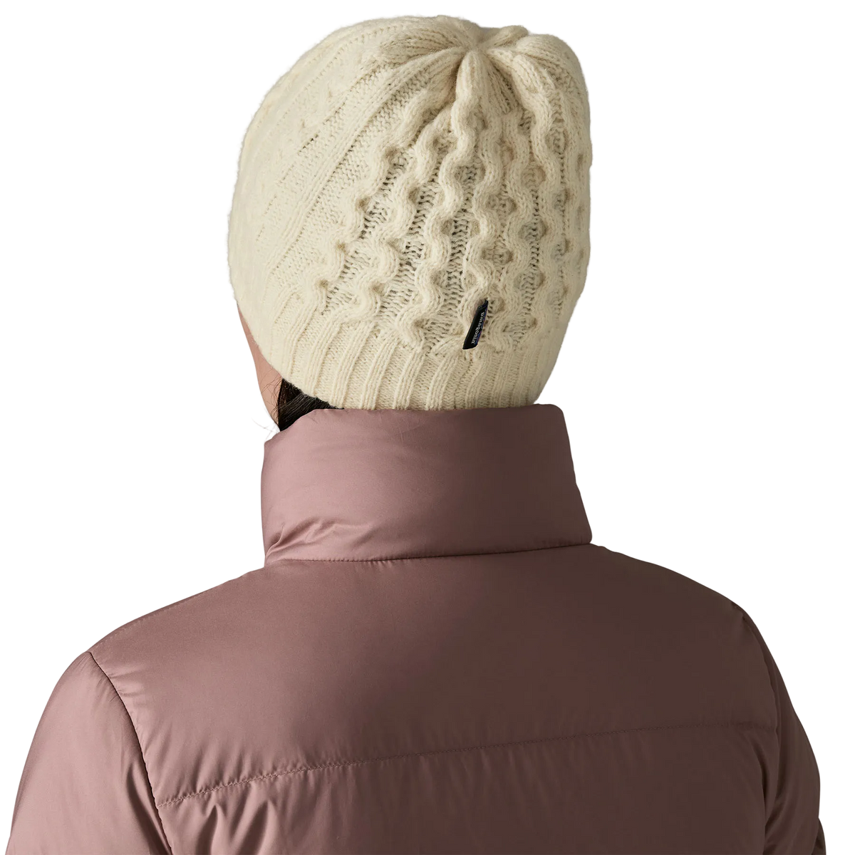 Rear view of a birch white Patagonia Coastal Cable Beanie featuring a recycled wool blend cable-knit body, an interior recycled polyester fleece headband lining, and a low-profile fit.
