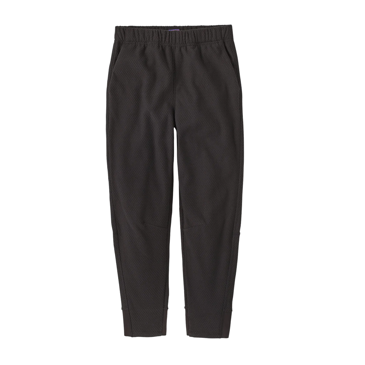 Front view of the black Patagonia Junior Midweight Layering Pants featuring 100% recycled pebbled-texture fleece fabric, a flat elastic waistband, a gusseted crotch, and flatlock seam construction.