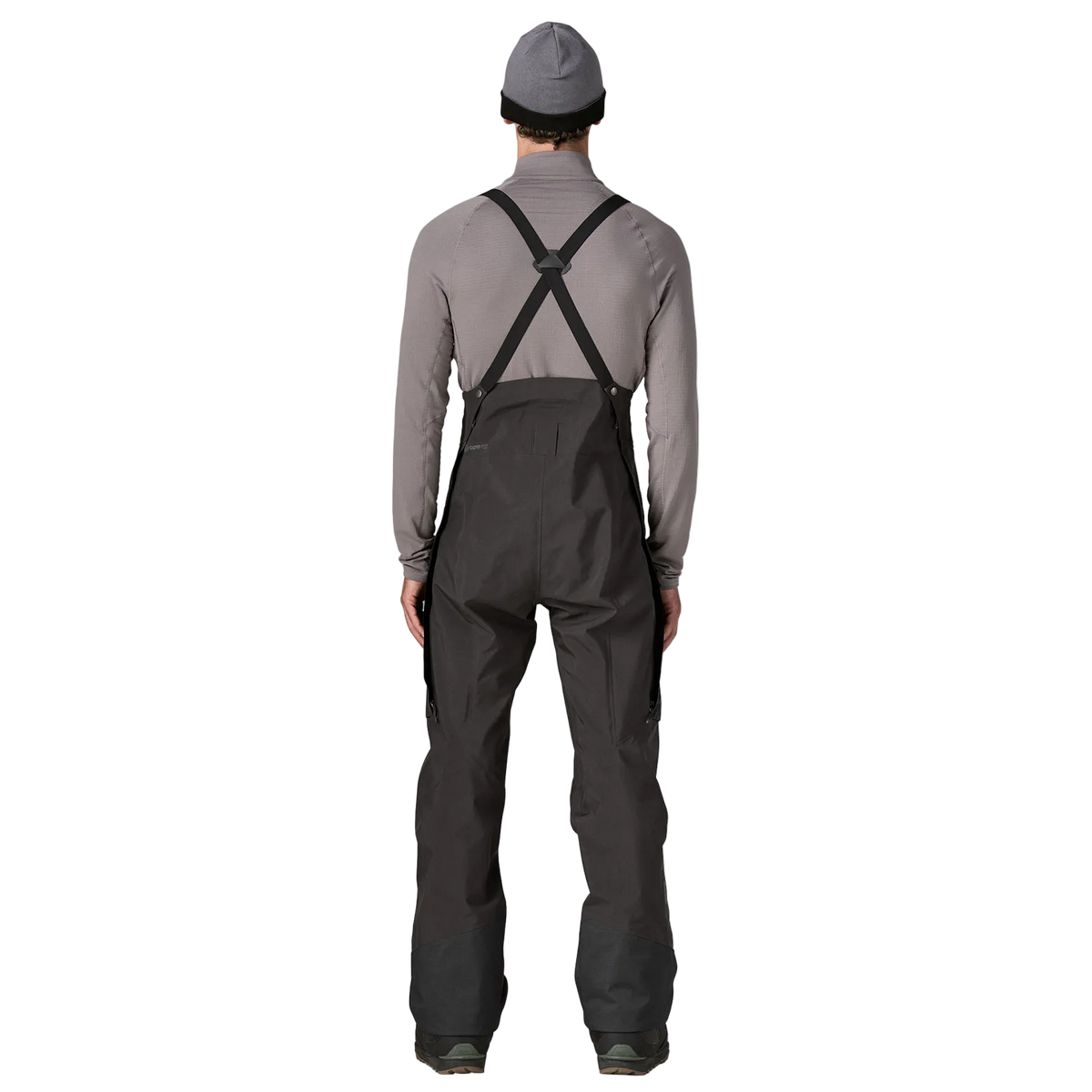 Rear view of the Patagonia Men's PowSlayer Bib Pants featuring a 3-layer GORE-TEX Pro shell construction with a 100% recycled nylon face fabric, a low-profile bib with adjustable elastic suspenders, a full-coverage drop-seat configuration, watertight Vislon side ventilation zippers, dual thigh cargo pockets, a central chest pocket, inner ankle scuff guards, internal boot gaiters with gripper elastic, and a built-in RECCO reflector.