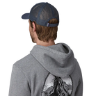 Rear view of a new navy Patagonia P-6 Logo LoPro Trucker Hat featuring an organic cotton canvas front crown, embroidered original artwork, NetPlus precurved brim, recycled polyester mesh back, and an adjustable rear snap closure.