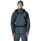 Front view of a black Patagonia SnowDrifter Pack 20L featuring weather-resistant recycled nylon ripstop fabric, diagonal ski and vertical snowboard carry loops, a front avalanche safety gear pocket, fleece-lined top goggle pocket, and shoulder harness accessory pockets.