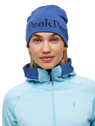 Front view of the Peak Performance Logo Hat featuring a soft double-layer knitted construction, fold-up cuff, stretch fit, and an embroidered front logo.