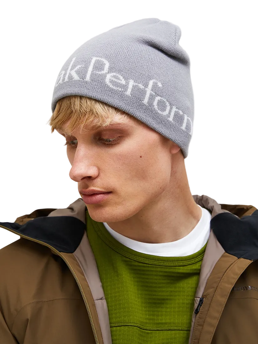 Front view of the Peak Performance Logo Hat featuring a soft double-layer knitted construction, fold-up cuff, stretch fit, and an embroidered front logo.