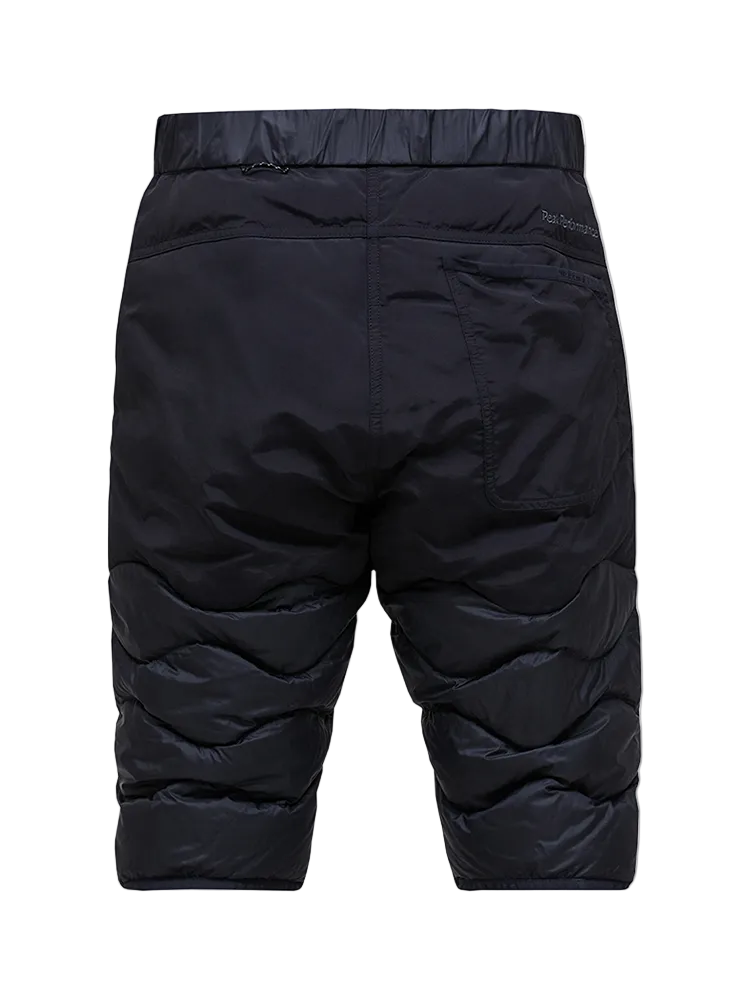 Rear view of black Peak Performance Men's Helium Down Shorts featuring ultra-lightweight windproof fabric, signature wave quilting, 700-fill-power down insulation, and full-length side zips.