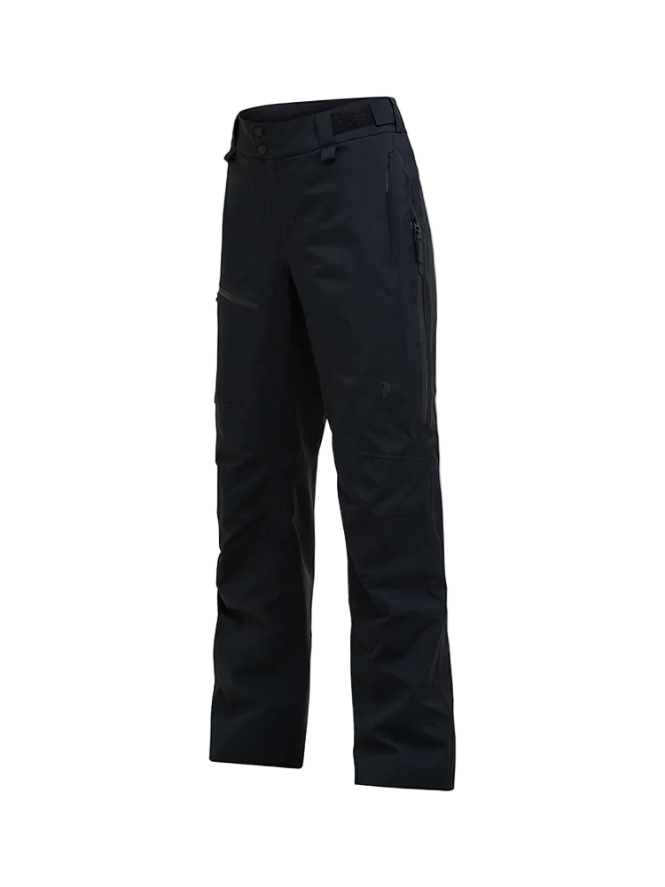 Side view of a black Peak Performance Women's Alpine GORE-TEX 2L Insulated Shell Pants featuring a 2-layer GORE-TEX waterproof membrane, YKK AquaGuard zippered thigh vents, an adjustable waistband, and reinforced Cordura scuff guards.
