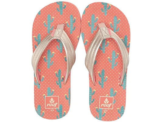 A pair of pink Reef Junior Ahi Cactus flip-flop sandals with green leaf pattern on a white background