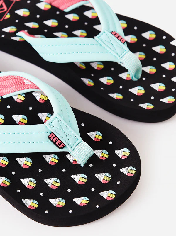Pair of black and teal Reef Junior Ahi Snowcone flip-flops with colorful ice cream pattern and Reef logo on a white background