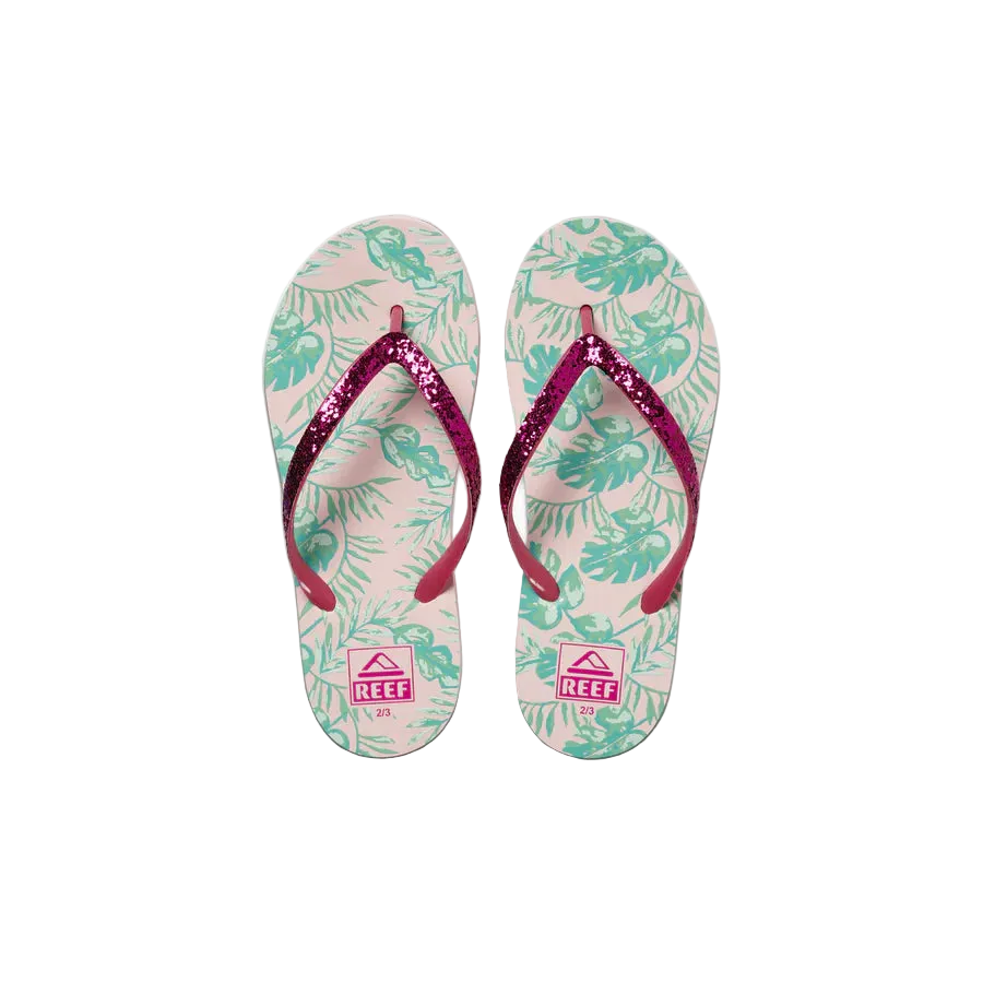 Pair of Reef Junior Stargazer Paradise flip-flops with pink straps and tropical leaf pattern on a white background