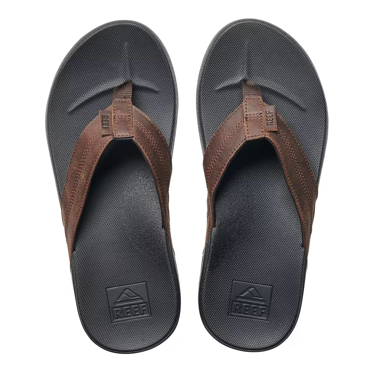 A pair of black and brown Reef Mens Cushion Bounce Phantom LE flip-flop sandals on a white background
