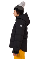 Side view of a black Rossignol Jr Boys’ Siz Quilted Jacket featuring high-loft synthetic insulation, quilted baffle construction, DWR-treated shell, high stand-up collar, and zippered handwarmer pockets.