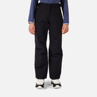 A girl wearing a pair of black Rossignol Girls' Insulated Ski Pants that are waterproof, breathable, stretchable, and warm.