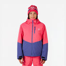 A girl wearing a pink and purple Rossignol Girls' Wispile Ski Jacket that is waterproof, insulated, breathable, and stretchable.