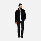 A man wearing a black Rossignol Men's All Track Snap Sherpa Jacket that is moisture-wicking, quickdrying, and warm.