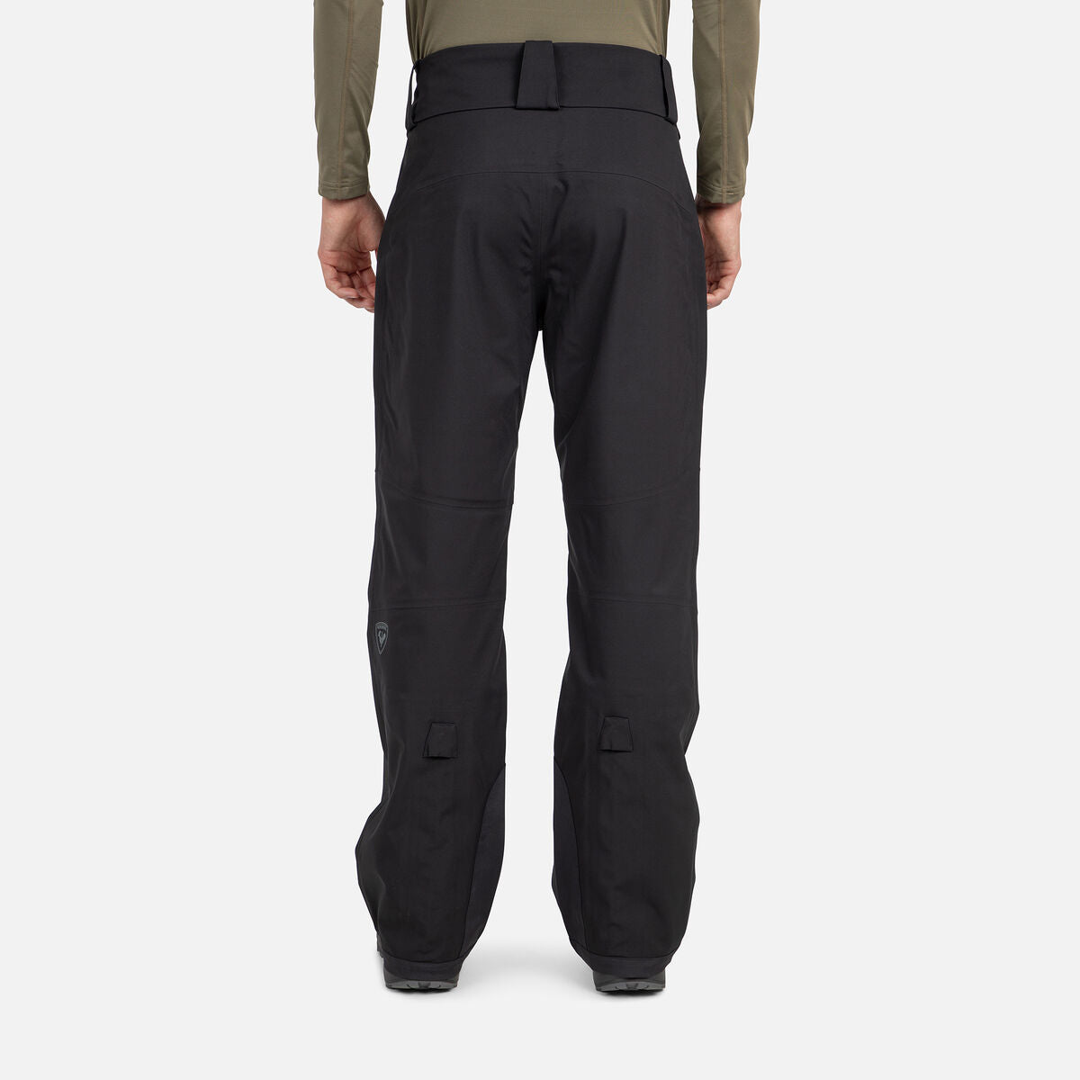 A man wearing a pair of black Rossignol Men's Evader Shell Ski Pants that are waterproof, breathable, and stretchable.