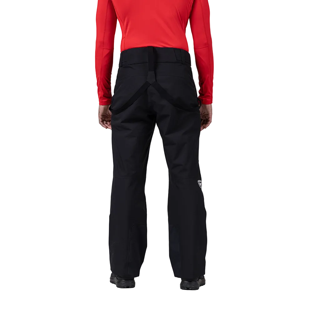 Rear view of black Rossignol Men’s Insulated Ski Pants featuring waterproof membrane fabric, synthetic insulation, adjustable waist tabs, integrated boot gaiters, and reinforced hem scuff guards.
