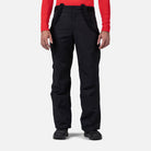 A man wearing a pair of black Rossignol Men's Insulated Ski Pants - Short, which feature a 30 inch inseam and are waterproof, breathable, stretchable, and warm.