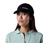 Front view of a black Rossignol Trucker Cap featuring a structured front panel, pre-curved visor, breathable rear mesh panels, and an adjustable snapback closure.