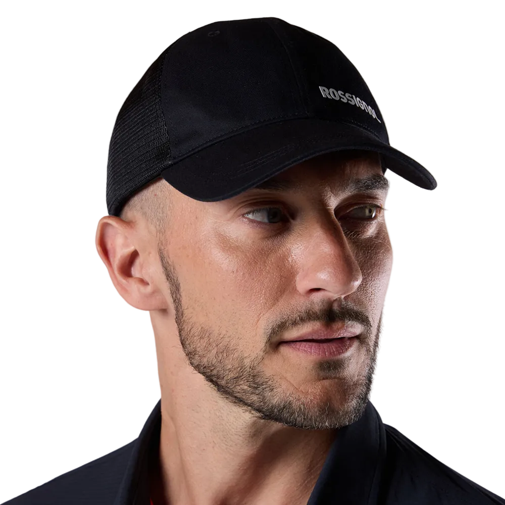 Front view of a black Rossignol Trucker Cap featuring a structured front panel, pre-curved visor, breathable rear mesh panels, and an adjustable snapback closure.