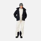 A woman wearing a pair of white Rossignol Women's Insulated Ski Pants that are waterproof, breathable, stretchable, and warm.