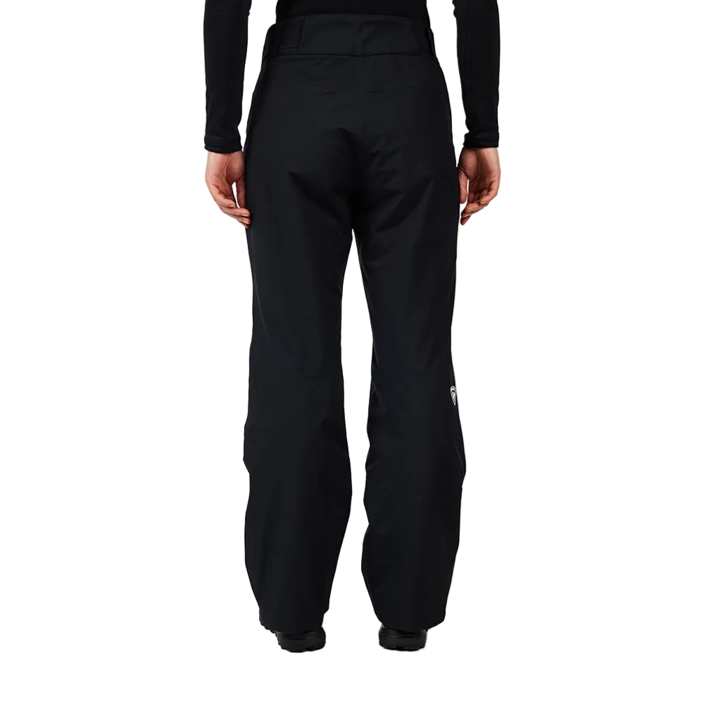 Rear view of black Rossignol Women’s Insulated Ski Pants featuring waterproof membrane fabric, synthetic insulation, adjustable waist tabs, integrated boot gaiters, and reinforced hem scuff guards.