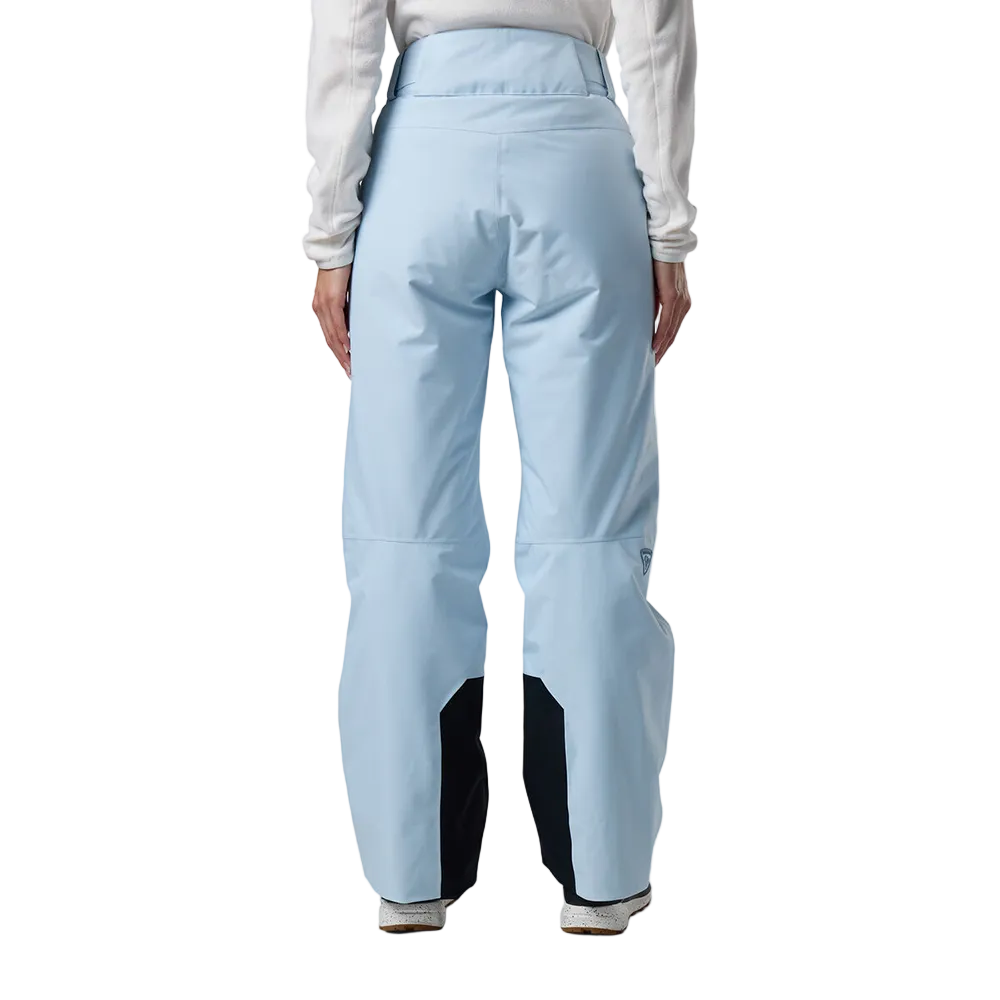 Rear view of blue aura Rossignol Women’s Insulated Ski Pants featuring waterproof membrane fabric, synthetic insulation, adjustable waist tabs, integrated boot gaiters, and reinforced hem scuff guards.