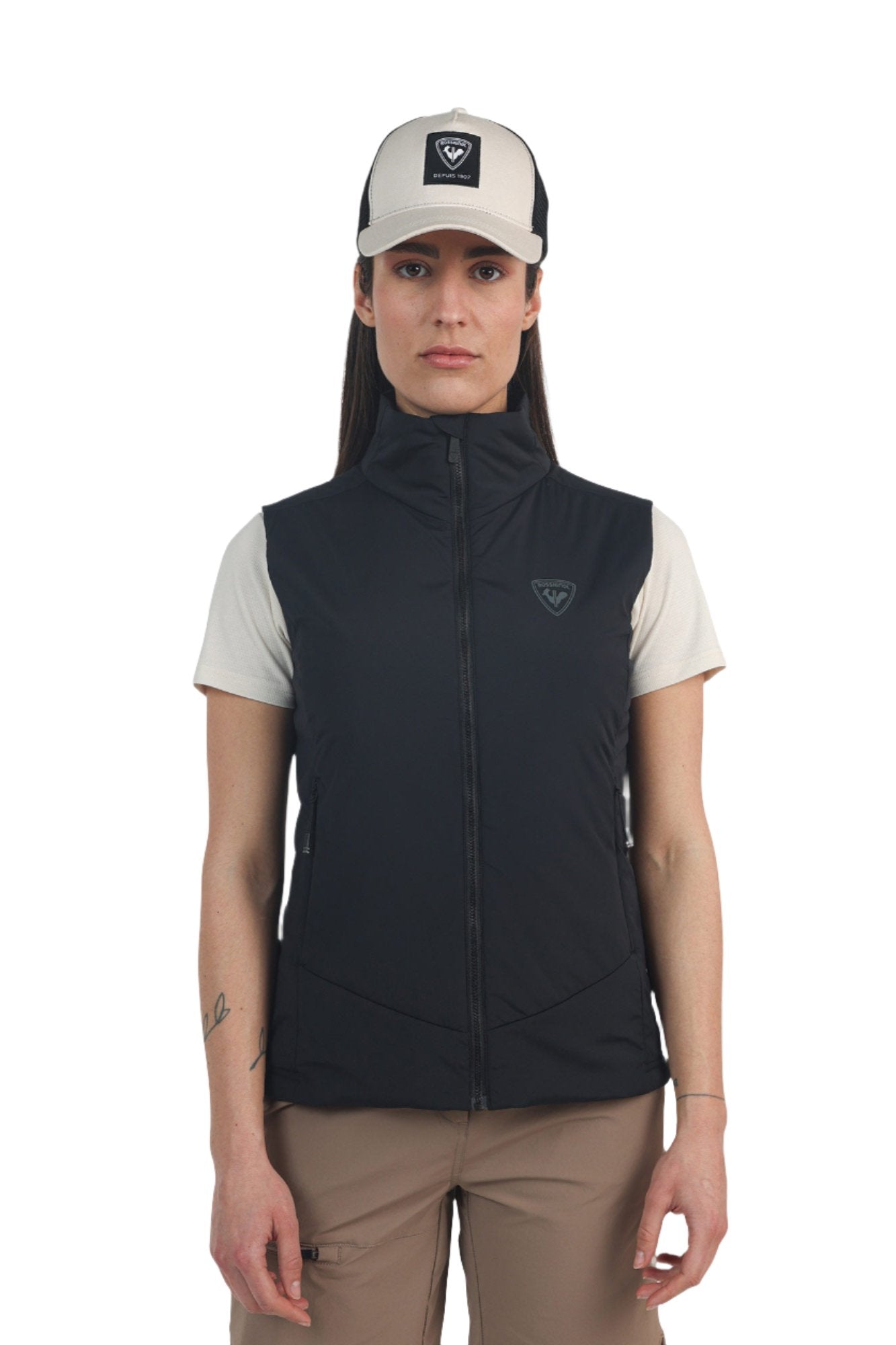 A woman wearing a black Rossignol Women's Opside Vest that is water-resistant, breathable, stretchable, lightweight, and insulated.