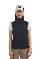 A woman wearing a black Rossignol Women's Opside Vest that is water-resistant, breathable, stretchable, lightweight, and insulated.