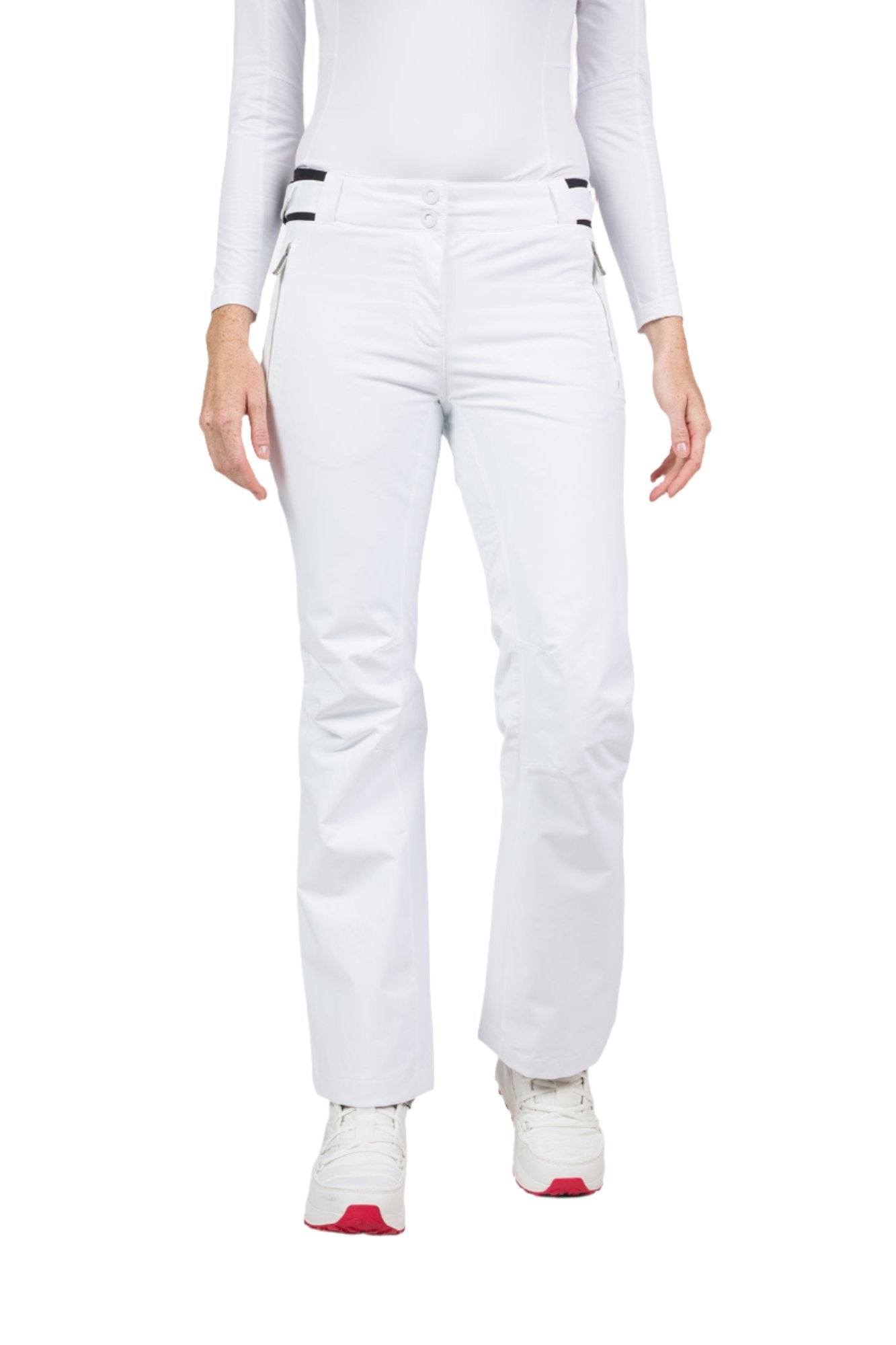  A woman wearing a pair of white Rossignol Women's Ski Pants that are waterproof, breathable, stretchable, and insulated.