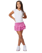 A girl wearing a white Sofibella Girls Spectrum Raglan Cap Sleeve Top and a pink skirt on a white background.