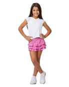 A girl wearing a white Sofibella Girls Spectrum Raglan Cap Sleeve Top and a pink skirt on a white background.