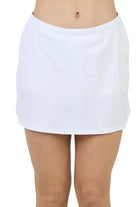A girl wearing a white Sofibella Girls Spectrum UV Skort with a multicolour design on a white background