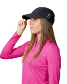 A woman wearing a black Sofibella Staples Snap Cap on a white background.