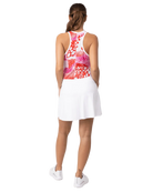 A woman wearing a white Sofibella Women's Staples 15" Skort and a multicolour top on a white background.