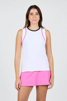 Woman wearing a white Sofibella Womens Style Icon Full Back Tank Top with pink trim and a matching pink skirt on a light gray background