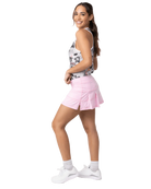 A woman wearing a pink Sofibella Women's UV Colors 14" Skort and a multicolour tank top on a white background.
