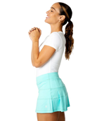 A woman wearing a white Sofibella Women's UV Colors Short Sleeve Top and a turquoise skirt on a white background.
