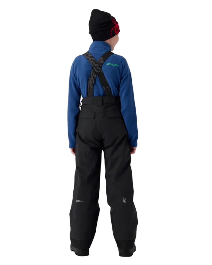 A boy wearing a Spyder Boys’ Propulsion Pants featuring EXO SHIELD 10K stretch recycled polyester shell, 60g ThermaWEB insulation, critically taped seams, removable adjustable suspenders, and inner snow gaiters.