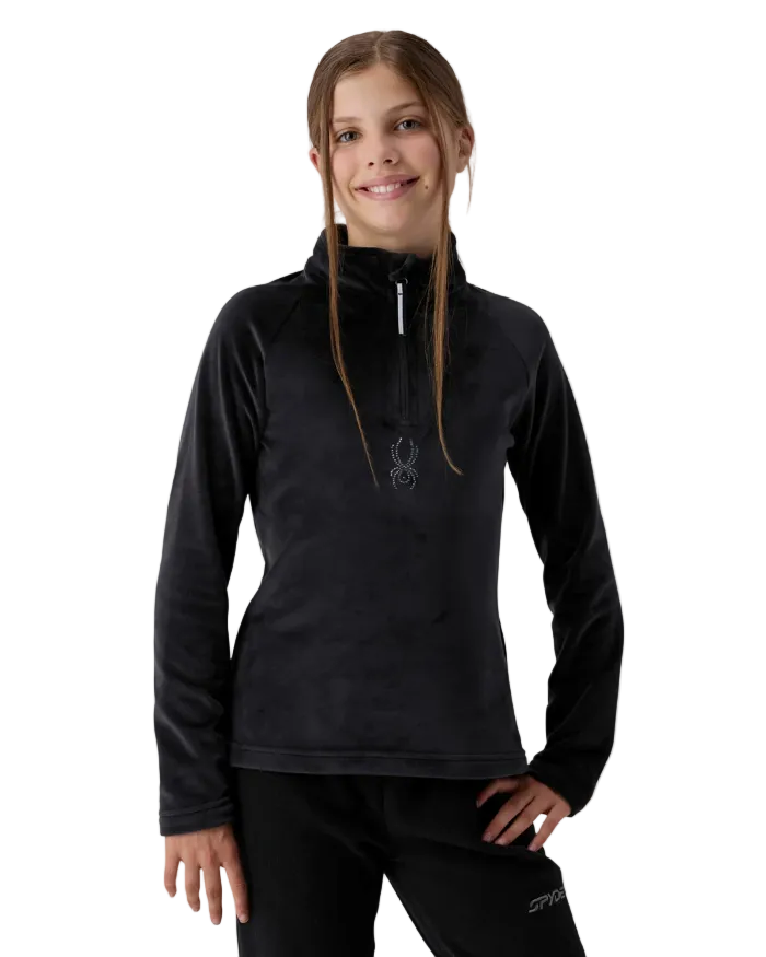 A girl wearing a Spyder Jr Girls’ Shimmer Bug 1/2 Zip Sweater featuring high-stretch velour fleece knit, YKK® reverse coil center front zipper, T-neck collar, and jeweled crystal logo.