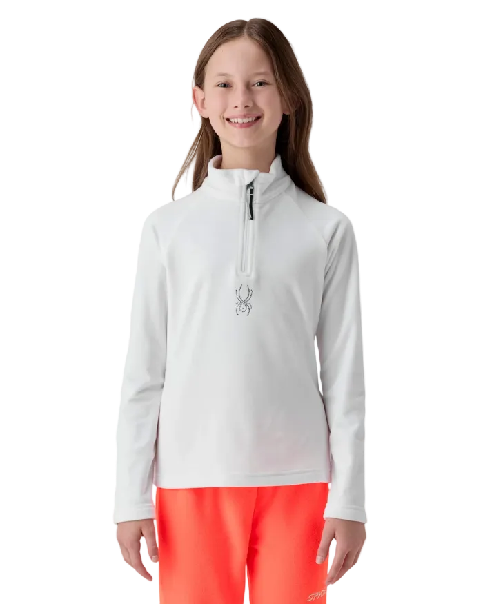 A girl wearing a Spyder Jr Girls’ Shimmer Bug 1/2 Zip Sweater featuring high-stretch velour fleece knit, YKK® reverse coil center front zipper, T-neck collar, and jeweled crystal logo.